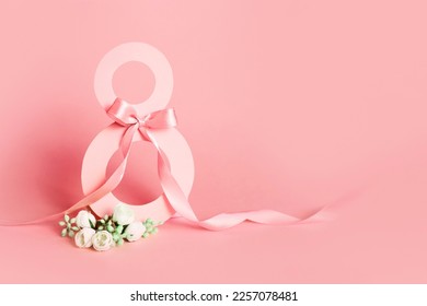 Paper cut eight with ribbon on pink background. Postcard March 8 on a pink background Stockfoto