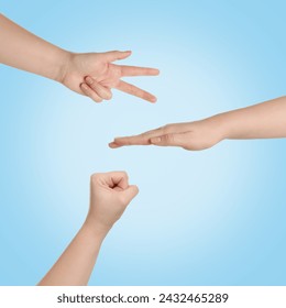 People playing rock, paper and scissors on light blue background, top view Stock-foto