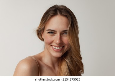 パーフェクトコスメトロジースキンケア。グレイのスタジオ背景にポーズを取り、カメラで微笑む完璧な顔を持つ優しい若い女性のポートレート。女性の医療ルーチン。美容、健康、広告の概念の写真素材