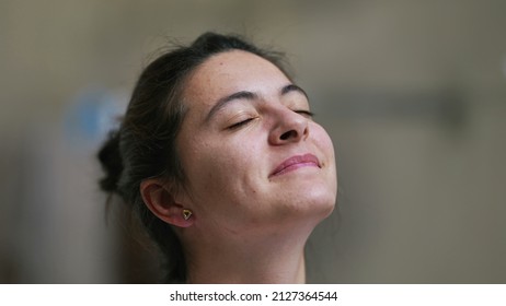 Person looking at sky closing eyes satisfied woman eyes closed in meditation Arkivfotografi