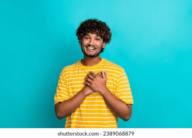 Photo portrait of attractive young man touch chest heart grateful dressed stylish striped yellow clothes isolated on cyan color background Arkistovalokuva