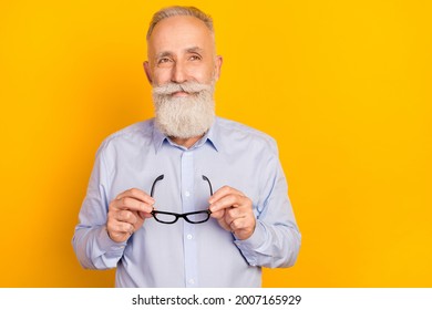 黄色い背景にポジティブなあごひげの老人の写真が空っぽの空間に見えるが、青い眼鏡のシャツを着ているの写真素材