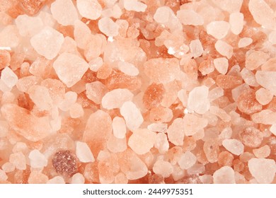 ピンクの塩の岩やヒマラヤの塩のテクスチャー。さまざまなオレンジ色から白の色調の多くの粗い塩岩のトップビュー。食べ物、プレゼンテーション、料理の風味を付けるために使用されます。限定フォーカス。の写真素材