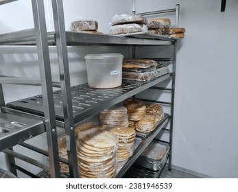 un montón de pan en una repisa dentro de un enfriador de marcha en una cocina envuelta en un envoltorio transparente de plástico y etiquetado con la fecha de producción Foto de stock
