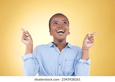 Pointing up, choice or excited black woman in studio for mockup space, sale news or deal offer. Yellow background, advertising or happy person thinking of promotion ideas, announcement or retail deal Foto stock
