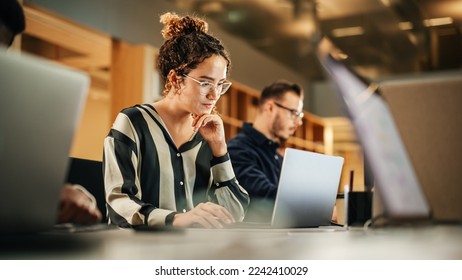 Portrait of Enthusiastic Hispanic Young Woman Working on Computer in a Modern Bright Office. Confident Human Resources Agent Smiling Happily While Collaborating Online with Colleagues. ஸ்டாக் ஃபோட்டோ