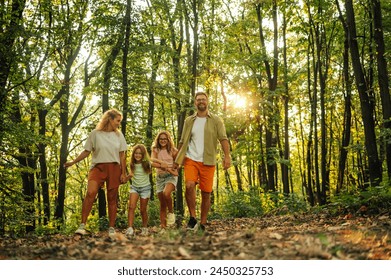 Portrait of a explorer family holding hands and taking a walk in nature. A young adventurous family is taking a walk in forest and exploring nature. Family holding hands and strolling in nature. – Ảnh có sẵn