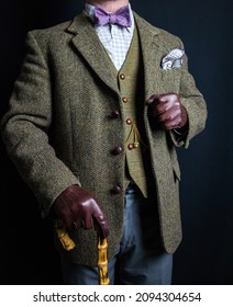 Portrait of Man in Tweed Suit and Leather Gloves Holding Umbrella on Black Background. Classic and Eccentric English Gentleman. 库存照片