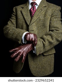 Portrait of Man in Tweed Suit Pulling on Leather Gloves. Vintage Style and Retro Fashion of British Gentleman. 库存照片