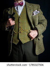 Portrait of Successful Man in Tweed Suit Holding Black Leather Gloves on Black Background. Concept of Classic and Eccentric British Gentleman Stereotype 库存照片