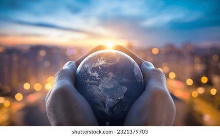 Planet Earth in the hands of a man against the background of the lights of the evening city. Concept and symbol on the theme of ecology, earth conservation. Elements of this image furnished by NASA. Stock Photo