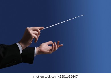 Professional conductor with baton on blue background, closeup Stockfoto