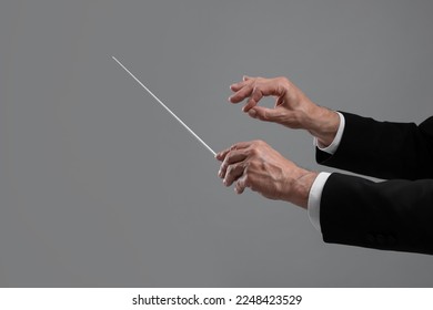 Professional conductor with baton on grey background, closeup Stockfoto