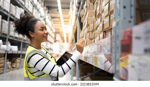 使用しているアフリカ人女性労働者 
デジタルタブレットコンピュータでTechnology.Checks在庫品は商品と棚の完全な小売倉庫で歩きます。の写真素材