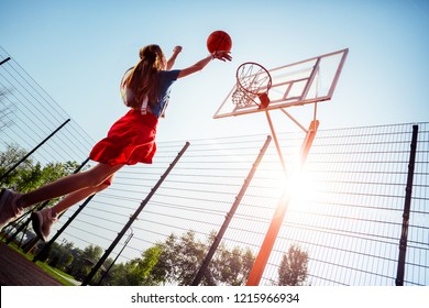 Professional player. Cheerful active teenager jumping high while playing basketball Foto stock