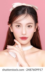 Pretty Asian woman model long hair perfect clear fresh skin smile on isolated pink background. Portrait elegant female beauty blogger make up artist in studio. Skincare, plastic surgery, spa concept. 库存照片