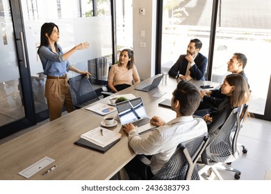 Mujer de negocios bonita dando un discurso de ventas a un grupo de clientes y empresarios en una sala de reuniones Foto de stock