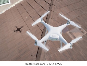 Quadcopter UAV Drone Flying A Residential Roof Inspection.: stockfoto