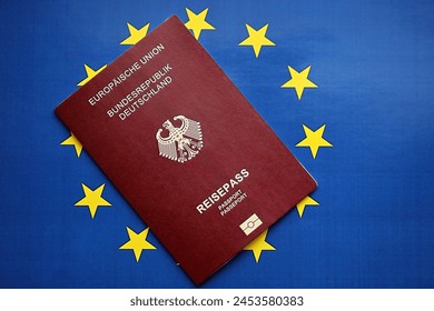 Pasaporte alemán rojo de la Unión Europea en el fondo de la bandera azul de cerca. Concepto de turismo y ciudadanía Foto de stock