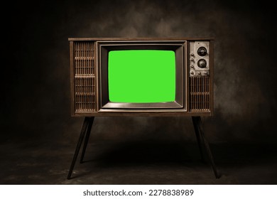 Retro old television with chroma key green screen standing in a dark room, antique and vintage TV style photo. Stock Photo