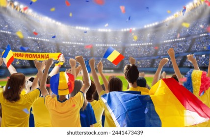 Romania football supporter on stadium. Romanian fans on soccer pitch watching team play. Group of supporters with flag and national jersey cheering for Romania. Championship game. Stock fotografie