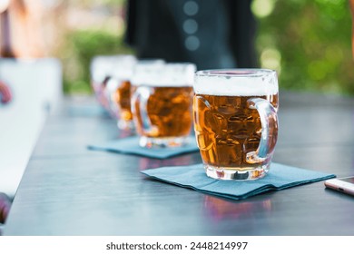 Row of beer glasses on an outdoor table - beer taste refreshing moment under the open sky, capturing the essence of social leisure time. – Ảnh có sẵn