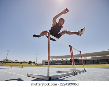 Running, jump and athlete hurdle for a speed exercise, marathon or runner training in a stadium. Short health, cardio and man run fast for a jumping competition or fitness workout for sports wellness Foto stock