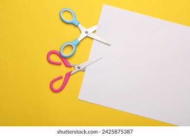 Scissors for creativity cut a white sheet of paper on a yellow background Stock-foto