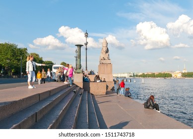 SAINT-PETERSBURG, RUSSIA – JULY 7, 2019: People take pictures and relax near Egyptian ancient sphinx on The Universitetskaya Embankment of The Neva River, fotografie de stoc Editorial