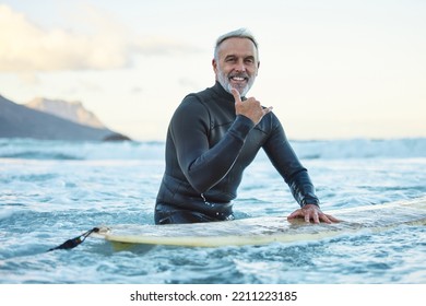 ハワイのビーチでサーフィンするシニアマン、サーフィン文化の手の信号と海洋自然の中で健康フィットネス。フレンドリーなサーファー簡単な挨拶、高齢者の退職旅行と海の冒険のライフスタイルの写真素材