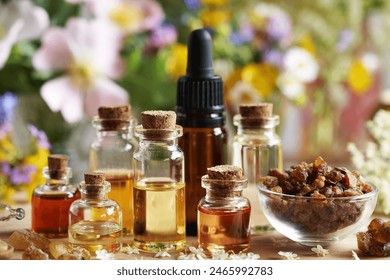 Selection of aromatherapy essential oil with myrrh, frankincense and spring flowers on a table: stockfoto