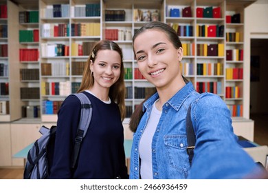 Selfie portrait of two girls high school students looking at camera inside classroom Adlı Stok Fotoğraf