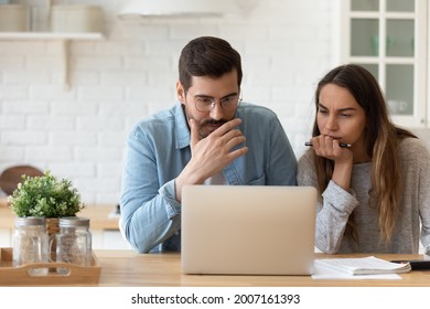 深刻な関心を持つ夫婦は、室内でノートパソコンを読み、銀行から過剰支出、財政債務、不安を感じ、新しい状況、高金利、税のコンセプトを知るの写真素材