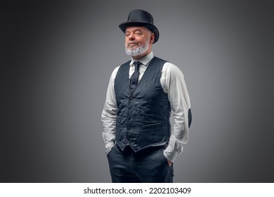 Shot of elderly man dressed in stylish old fashioned costume with top hat. 库存照片
