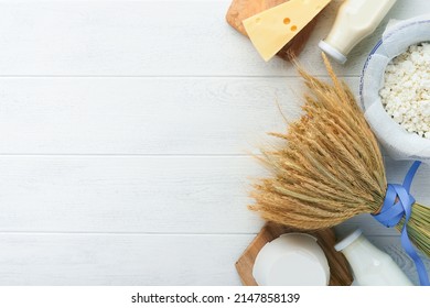 Shavuot jewish holiday celebration. Milk and cheese, ripe wheat and fruits, cream on white wooden background. Dairy products over white wooden background. Shavuot concept. Top view. Mock up. Stock-foto