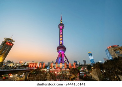 Shanghai, China - March 16th 2024: Busy traffic road with The Oriental Pearl Tower at night. The Oriental Pearl Tower is a TV tower in Shanghai, China. It's very famous. It's very iconic.: redactionele stockfoto