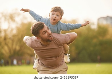 사람의 어깨에 앉아. 아들을 둔 해피 파더가 여름이면 밭에서 즐거운 시간을 보내고 있다. 스톡 사진