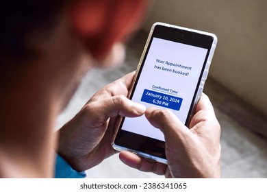 A South Asian man checking smartphone notification for his upcoming appointment. Online appointment booking and scheduling concept. Stock fotografie