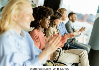 Smiling woman leads a round of applause with peers, sharing a moment of joy: stockfoto