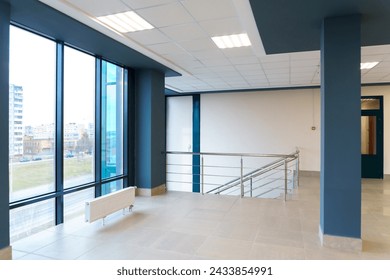 A spacious empty room with columns and no furniture. The concept of a comfortable office. The interior space of a modern office building. Bright and clean interior design of a luxurious living room. Adlı Stok Fotoğraf