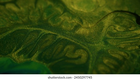 Sparkling paint drip. Wet glitter texture. Defocused green color metallic golden shiny sand particles acrylic dye ink fluid swirl mix abstract art background. 库存照片