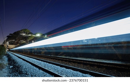 夜の星空の下のレール上の移動に高速列車のカラフルな光の壮大なビューの写真素材