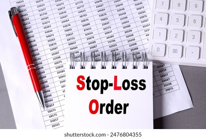 STOP-LOSS ORDER text on a notebook with chart , pen and calculator.  库存照片
