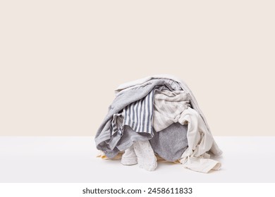 Stack of gray dirty clothes waiting for laundry isolated on light beige background – Ảnh có sẵn
