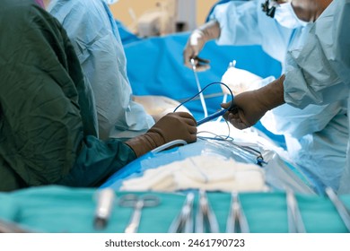 Sterile surgical instruments and tools including scalpels, scissors, forceps and tweezers arranged on a table for a surgery, Sterilized surgical instruments on the blue or green wrap	 Stock-foto