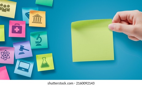 Sticky notes with school subjects icons, a student is holding a note with blank copy space Stock Photo
