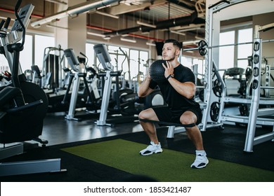 Strong man doing squats with ball. Foto stock