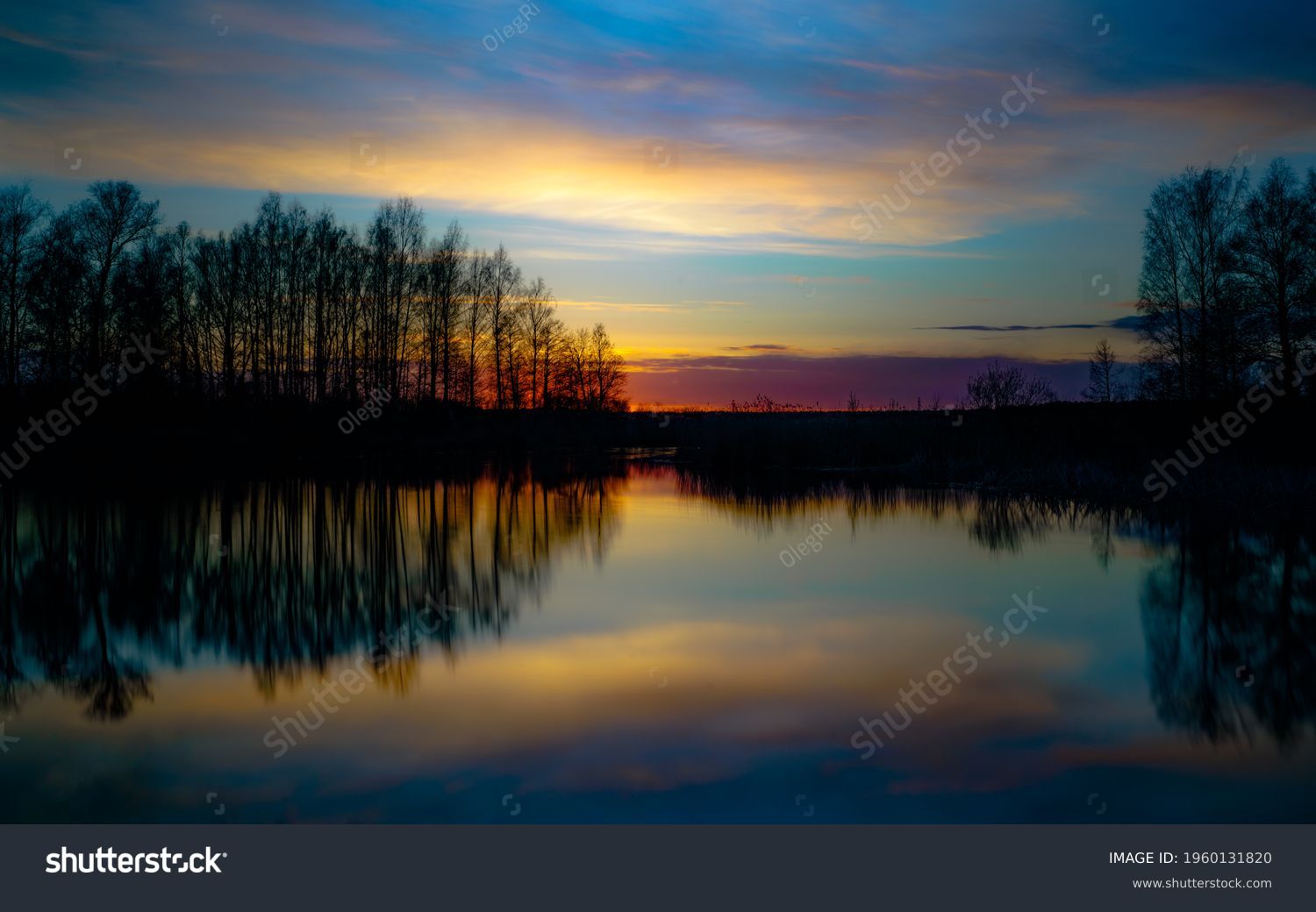 sunset at coast of the lake. Nature landscape. Nature in northern Europe. reflection, blue sky and yellow sunlight. landscape during sunset. Stock Photo
