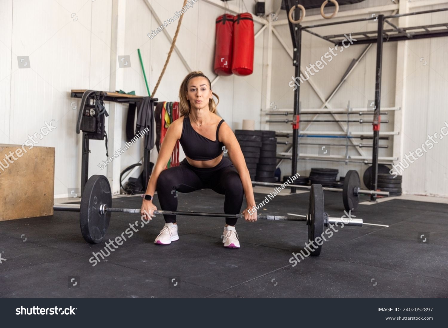 Fitness woman lifting barbell in the gym