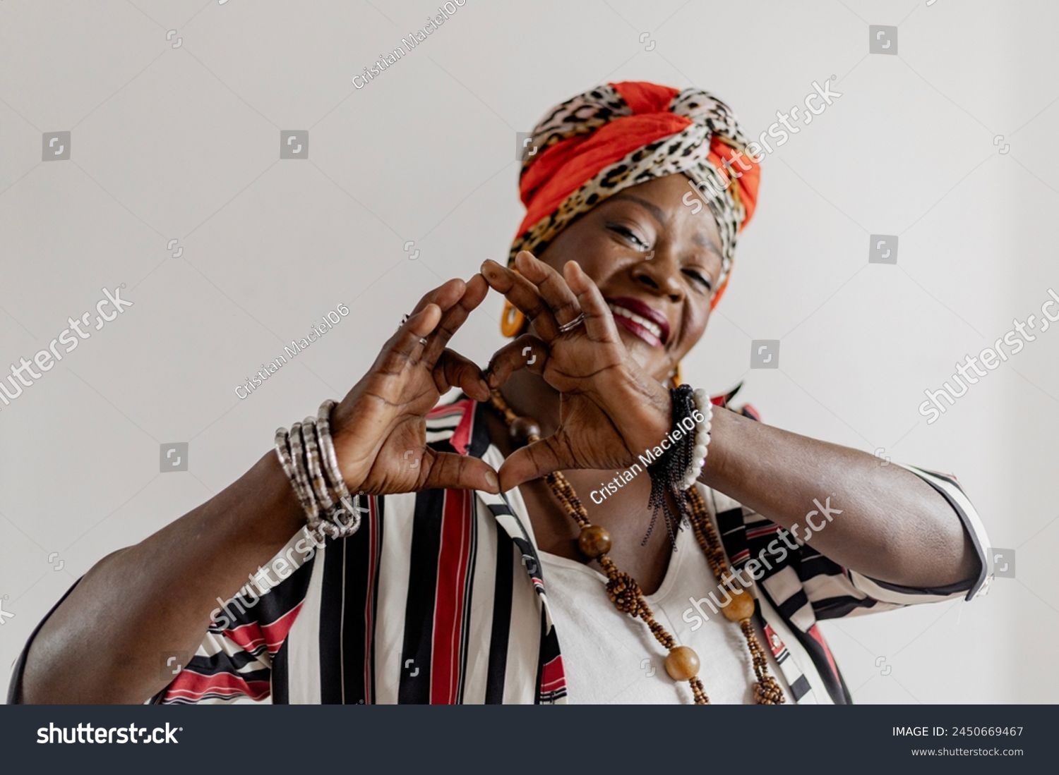 Portrait of a beautiful happy and smiling mature woman at home, making photos for Mother's Day. Smiling African woman wearing colorful African clothes for Mother's Day.